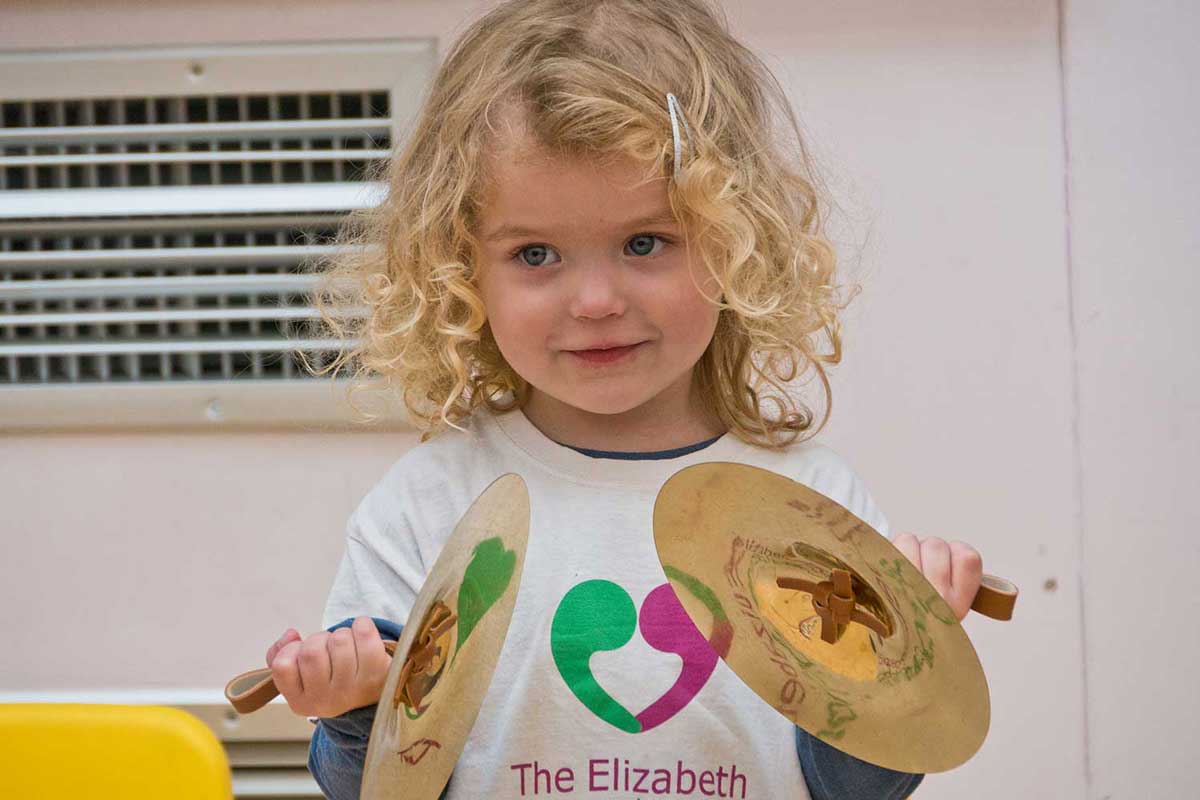 Deaf girl holding cymbals at The Elizabeth Foundation